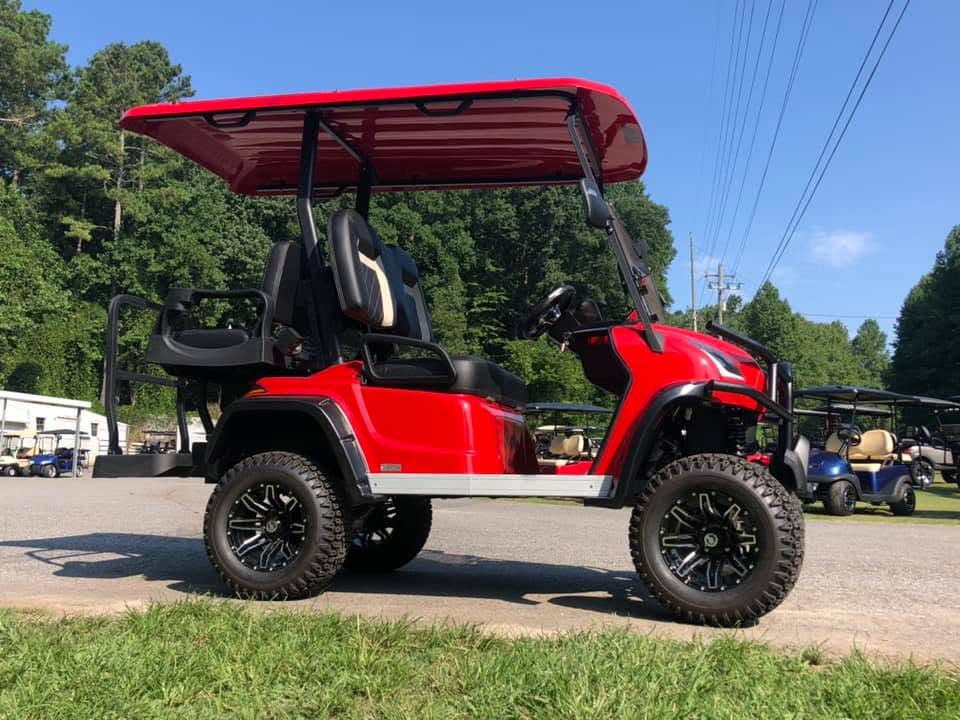 Red lifted golf cart with off-road tires at a Dawsonville dealership
